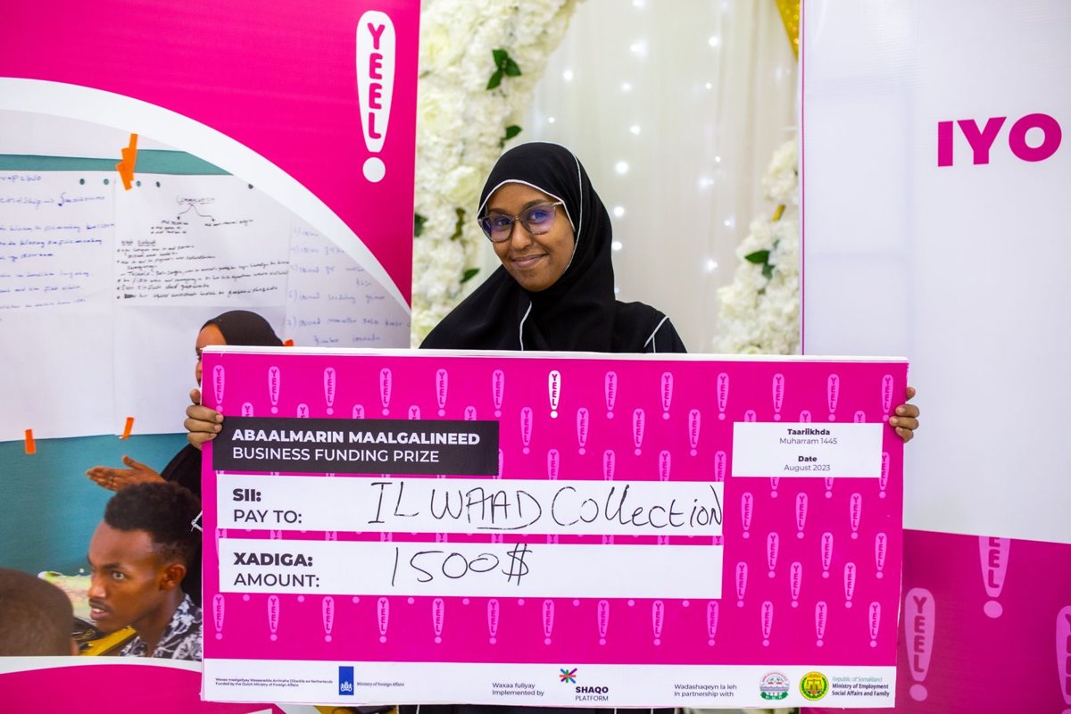 A graduate holding her seed funding award