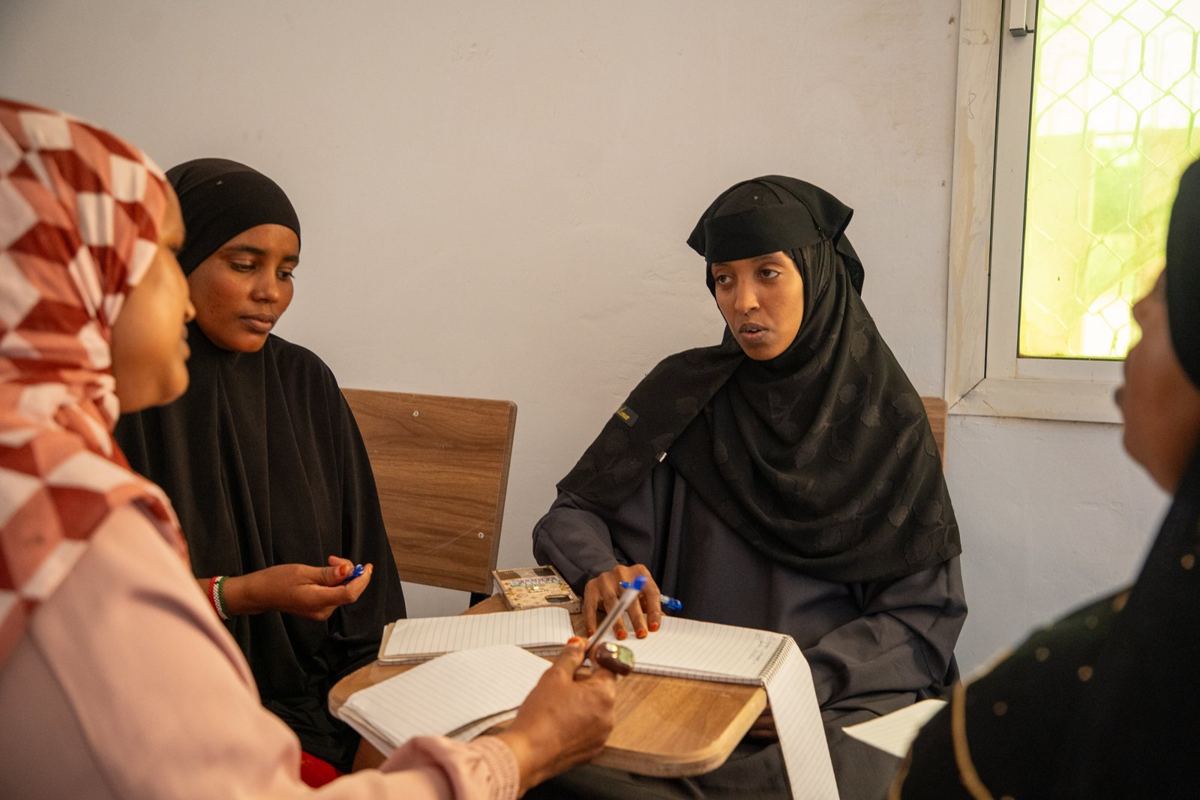 Two women writing during a class