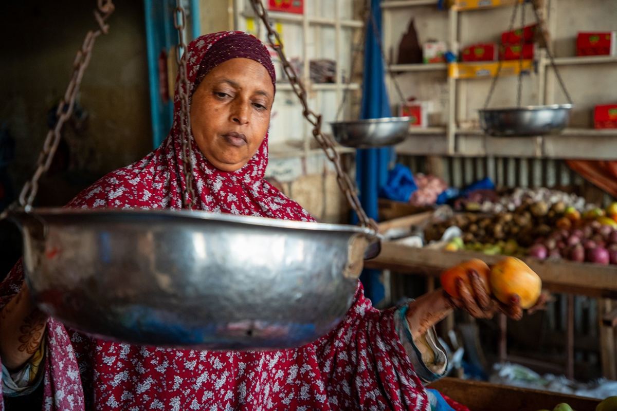A woman weighing produce at her stall