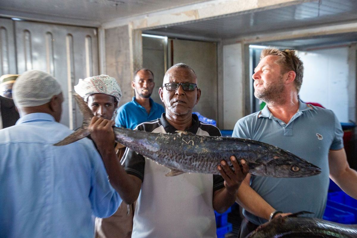 Partners and fishers holding fresh fish