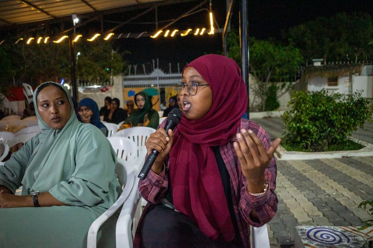 A young woman speaking at a WOMPOL event